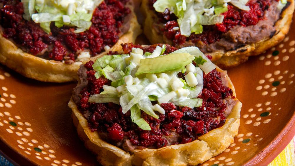 Sopes preparados, con frijol, carne, lechuga romana, queso y aguacate