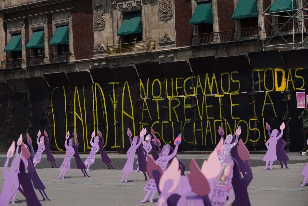 Zócalo capitalino amurallado previo al 8M. Cientos de siluetas moradas protestan contra la violencia y la impunidad en feminicidios.