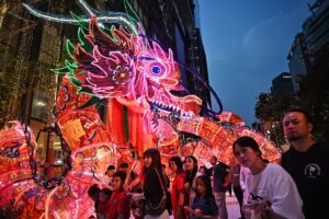 Personas en una celebración del Año Nuevo Lunar con decoración roja, faroles y ambiente festivo