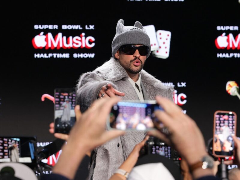 Bad Bunny vistiendo traje gris y gorro durante la rueda de prensa de la NFL en San Francisco.