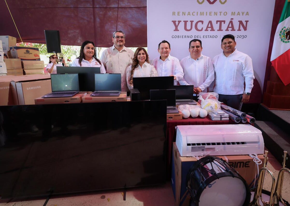 Fila de paquetes y materiales educativos apilados en el patio de una escuela preparatoria estatal.