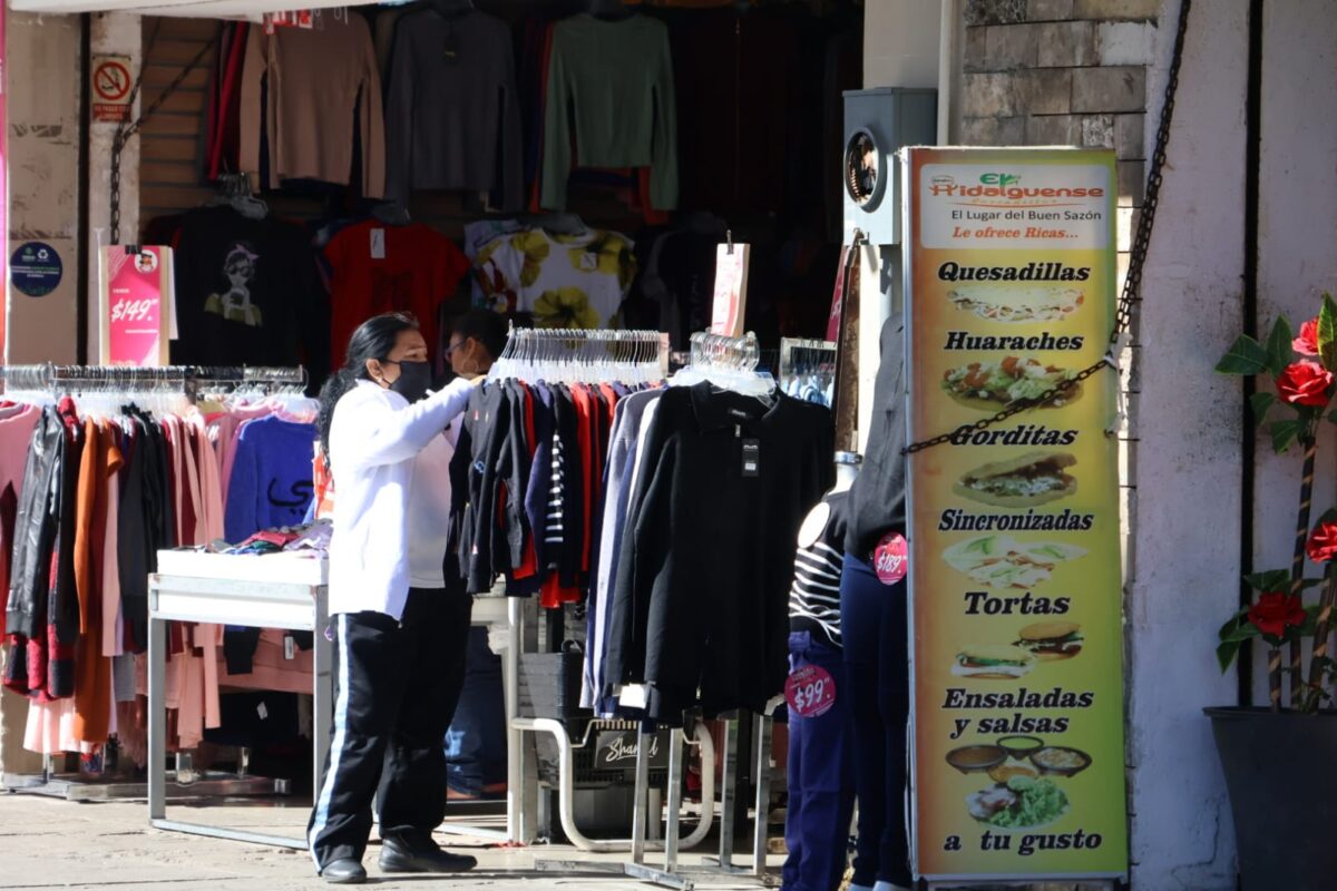 Personas comprando chamarras y suéteres en un local comercial del Centro Histórico de Mérida.