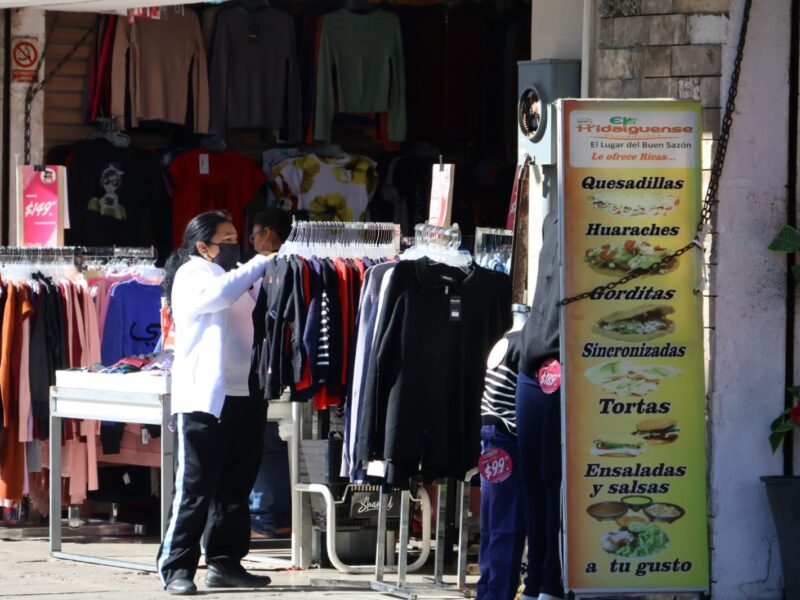 Personas comprando chamarras y suéteres en un local comercial del Centro Histórico de Mérida.